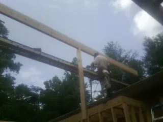 Carpenter setting a ridge beam over a new addition frame — Ice Dam Removal by Roofing Brothers in Lockport